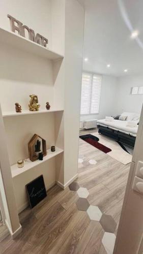 Ein weißes Zimmer mit einem Schlafzimmer und einem Bett. in der Unterkunft Studio cosy Buttes-Chaumont in Paris