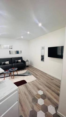 ein Wohnzimmer mit einem Sofa und einem Tisch in der Unterkunft Studio cosy Buttes-Chaumont in Paris