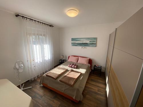 een kleine slaapkamer met een bed en een raam bij Apartment Bigi in Novi Vinodolski
