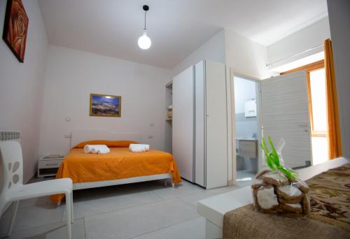a bedroom with an orange bed and a bathroom at Nonno Giovanni in Gangi