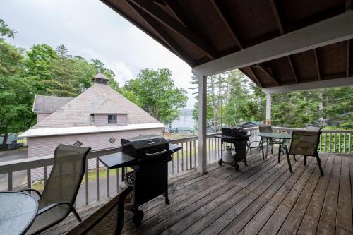 a deck with tables and chairs and a grill at Depe Dene Lakeside Resort in Lake George