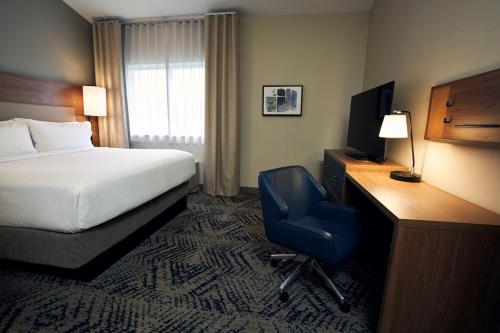 a hotel room with a bed and a desk and a chair at Candlewood Suites Charleston – Mt. Pleasant by IHG in Charleston