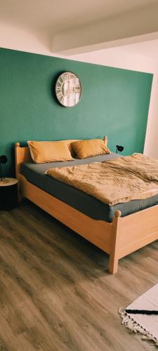 um quarto com uma cama e uma parede verde em Ferienwohnung Trinitatis em Sondershausen