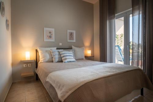 a bedroom with a bed with two lamps and a window at Leas House in Preveza