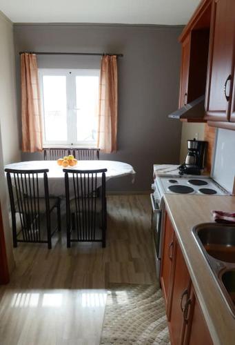 a kitchen with a table and chairs and a kitchen with a window at ΜΕ ΘΕΑ ΤΗΝ ΓΟΡΓΟΝΑ in Preveza
