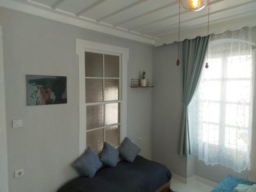 Mimosa House Ayvalık في أيفاليك: غرفة معيشة مع أريكة ونافذة