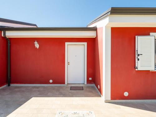 a red garage with a white door and a window at Villa Lunu in Quartu SantʼElena