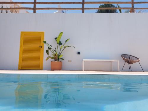 uma piscina com uma porta amarela e uma planta em Casa A.Mar em Las Negras