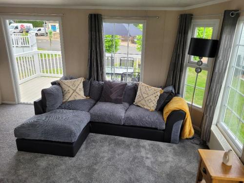 a couch sitting in a living room with windows at Cherry Blossom Retreat in Felton