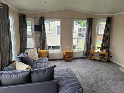 a living room with a blue couch and windows at Cherry Blossom Retreat in Felton