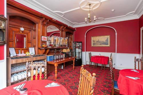 a dining room with red walls and a red table at Elim Bank Guest House in Bowness-on-Windermere