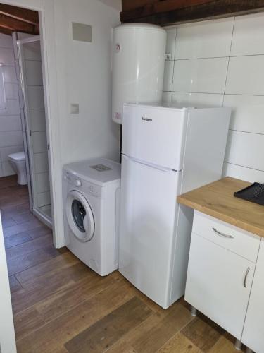 a kitchen with a washing machine and a refrigerator at Alojamiento con finca en Gijón 