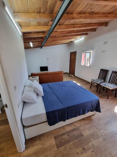 a bedroom with a large bed and wooden ceilings at Alojamiento con finca en Gijón 