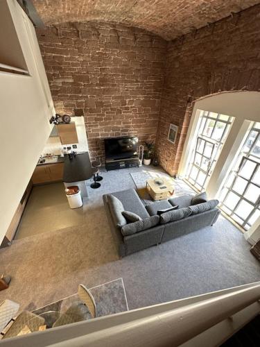 a living room with a couch and a brick wall at The Engine House in Carlisle