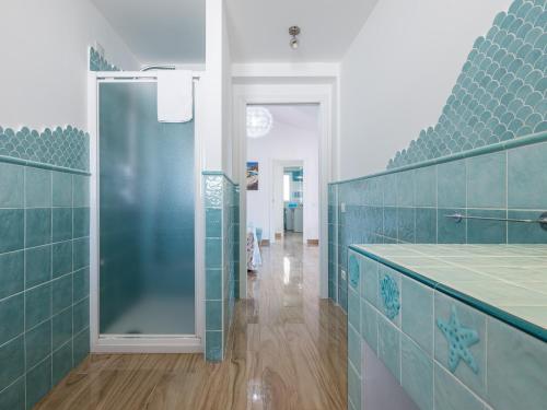 ein Badezimmer mit blauen Fliesenwänden und einer Dusche in der Unterkunft Villa Lunu in Quartu SantʼElena
