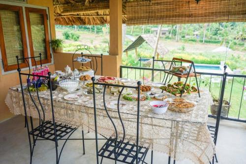 una mesa con comida y sillas en Amandawa Eco, en Gampaha