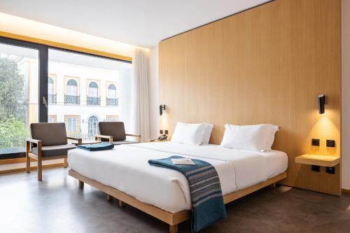 Evora Olive Hotel في ايفورا: غرفة نوم بسرير كبير ونافذة كبيرة