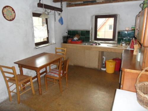 cocina con mesa y sillas en una habitación en Animal Farm - agroturystyka konik polski, en Przecznica