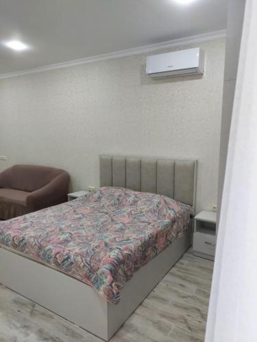 a bedroom with a bed and a chair in it at Kobuleti Rezidens Studio apartament Giorgi in K'obulet'i