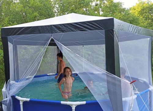 a young child in a swimming pool in a tent at Еко-садиба БАКОТА in Kolodiyevka