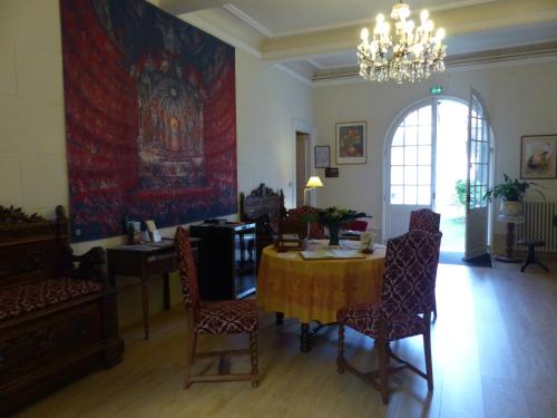 a dining room with a table and chairs and a chandelier at Hôtel du Fiacre in Carpentras