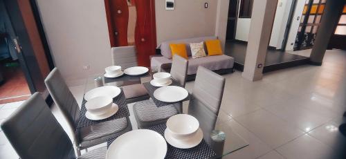 ein Wohnzimmer mit weißen Tischen und Stühlen sowie einem Sofa in der Unterkunft Apartamento Banda de Shilcayo in Tarapoto