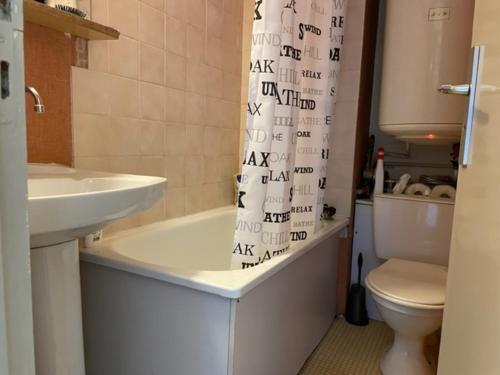 a bathroom with a sink and a toilet and a shower curtain at Le Cow'sy 1800 in Les Deux Alpes