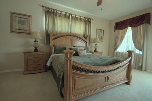 um quarto com uma cama grande e duas mesas de cabeceira em Entire home with pool and lake view and Golf course by Disney em Davenport