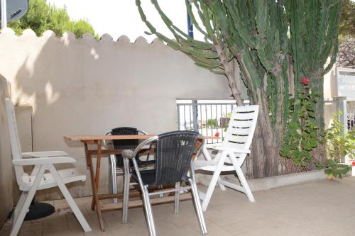 3 sillas y una mesa en un patio en Appartamenti Fronte mare en Siniscola