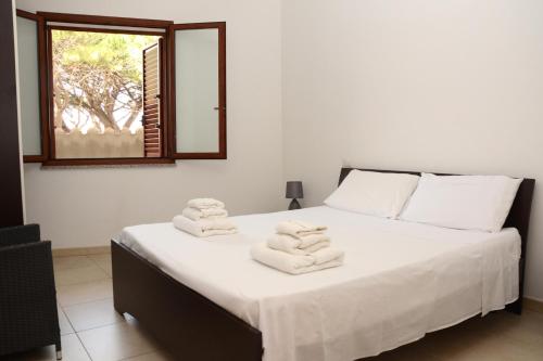 una camera da letto con un letto e asciugamani di Appartamenti Fronte mare a Siniscola