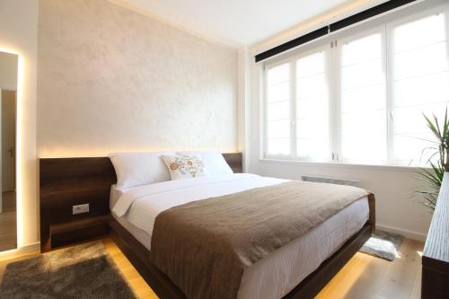 a bedroom with a bed and a large window at MAGIC Apartments in Sarajevo