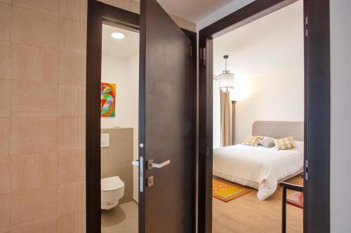 Cette chambre comprend un lit et une porte menant à une chambre. dans l'établissement Casa Anatella, à San-Martino-di-Lota