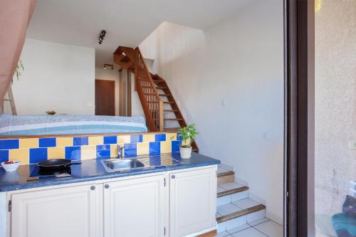 - une cuisine avec un évier et un escalier dans la chambre dans l'établissement Casa Les Marines, à San-Nicolao