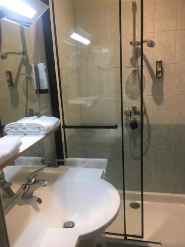 a bathroom with a shower and a sink and a toilet at HOTEL LES MARRONNIERS in Thueyts