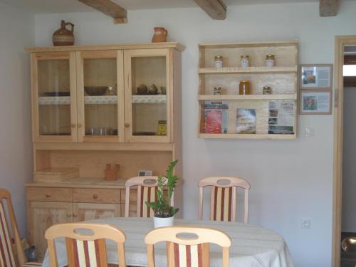 a kitchen with a table with chairs and cabinets at Gerendás Vendégház in Sótony