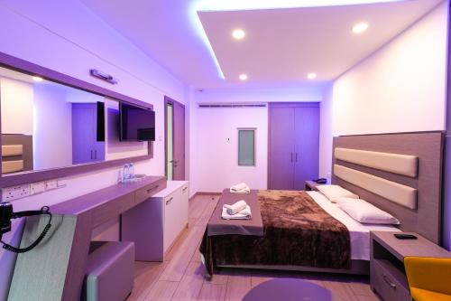 a bedroom with a bed and a bathroom with a sink at Captain Pier Hotel in Protaras
