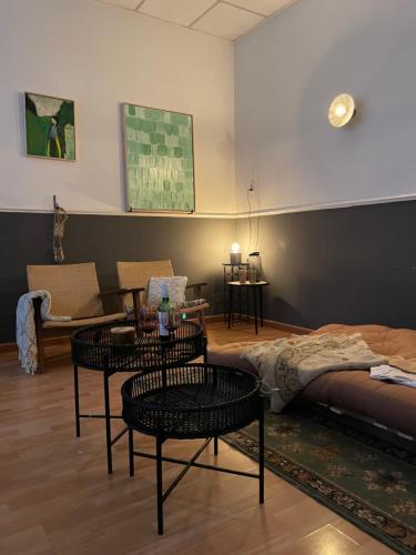 uma sala de estar com duas mesas e uma cama em Casa Elburg em Elburg
