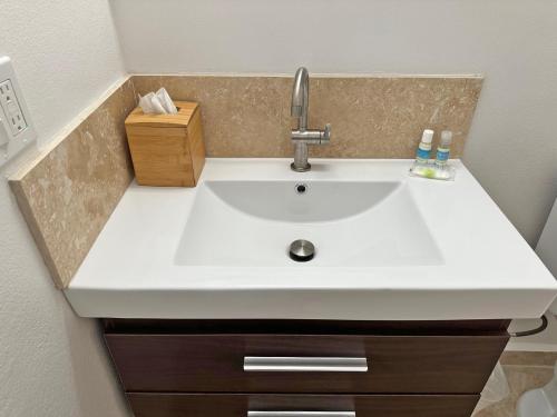 a white sink in a bathroom with a counter at Sand Castle on the Beach - Adults Only in Frederiksted