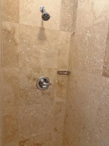a shower with a metal shower head in a bathroom at Sand Castle on the Beach - Adults Only in Frederiksted