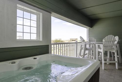 a jacuzzi tub in a room with a balcony at FFR101 - The Wright Idea in Kill Devil Hills