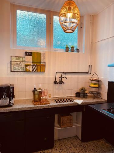a kitchen with a counter with a sink and two windows at Casa Elburg in Elburg