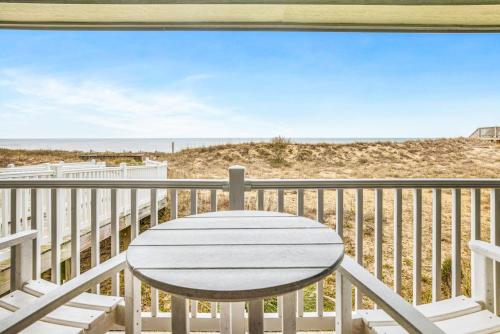 a table on a balcony with a view of the beach at FFR114 - Nemo's Retreat in Kill Devil Hills