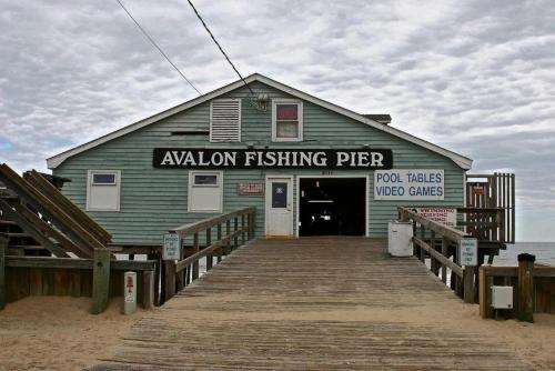 a building on the beach with a pier at FFR114 - Nemo's Retreat in Kill Devil Hills