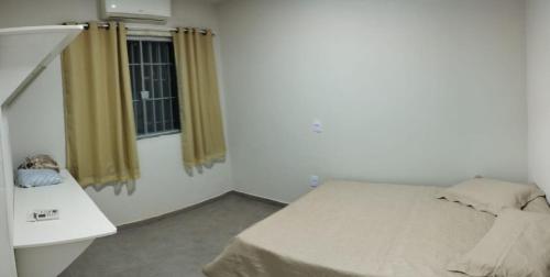 Habitación pequeña con cama y ventana en Residencial Casa Grande - Apto 02, en Santa Cruz Cabrália