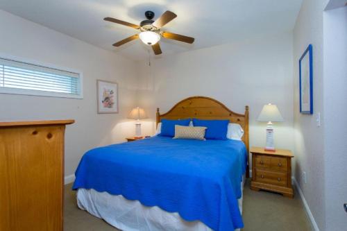 a bedroom with a blue bed and a ceiling fan at FFR202 - Atlantic Splash in Kill Devil Hills