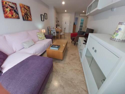 a living room with a couch and a table at Apartamento La Porteña, 200 ms de playa Victoria in Cádiz