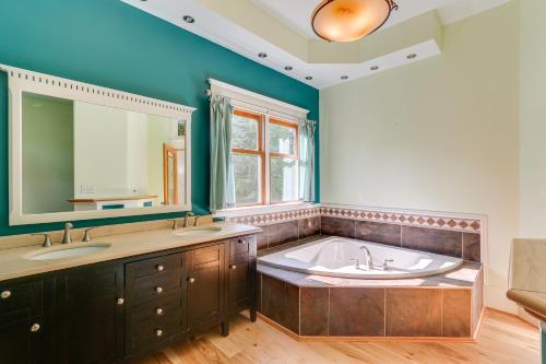 a bathroom with a tub and two sinks and a mirror at Bright Bluemont Home with On-Site Pond and Mtn Views! in Paris