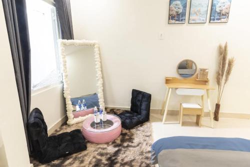 a living room with a mirror and a chair at Cloud River Homestay in Da Lat