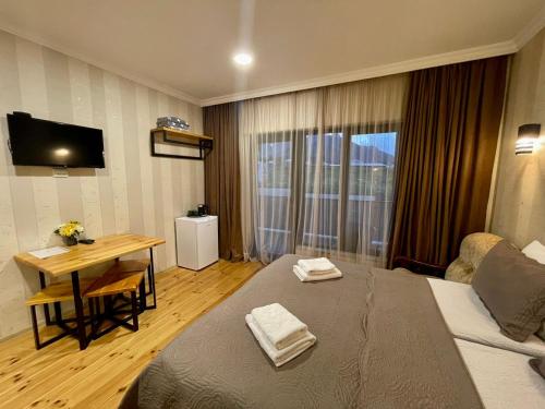 Una habitación de hotel con una cama y una mesa con toallas. en Bibo's Kokhi Guesthouse en Kazbegi