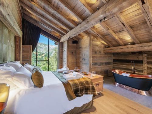 sypialnia z dużym łóżkiem i wanną w obiekcie Chalet de prestige avec jacuzzi, sauna et cinéma - FR-1-570-42 w mieście Saint-Martin-de-Belleville